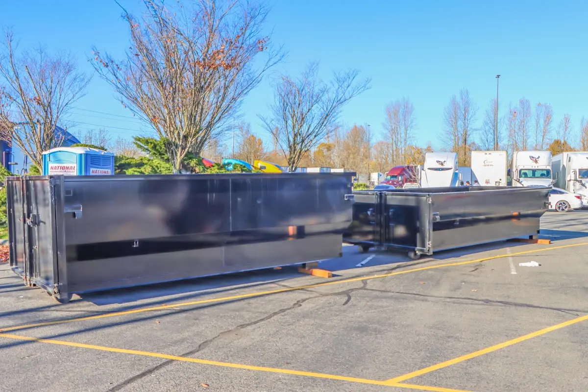 Professional dumpster rental service with roll-off container on residential driveway in Nibley